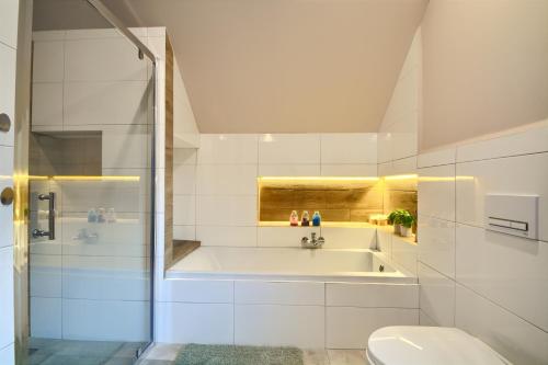塔干尼采Przystanek Leśna的白色的浴室设有浴缸和卫生间。