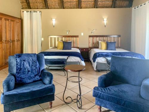 马布拉Zebula Golf Estate and Spa - Zebula Golfers Lodge的酒店客房,配有两张床和两把椅子