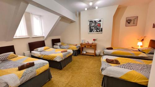 利物浦Castle Lodge Guest House 86-88 Sheil Rd L6 3AF的一间设有4张黄色和蓝色床铺的客房