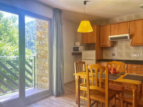 阿林萨尔Vista Arinsal Apartments的厨房以及带桌子和窗户的用餐室。