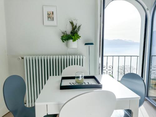 PuidouxRoom with 360° view overlooking Lake Geneva and Alps的白色的桌椅和阳台的景色