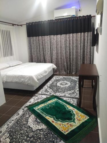 Nor@az RoomeStay的卧室配有一张床,地板上铺有地毯