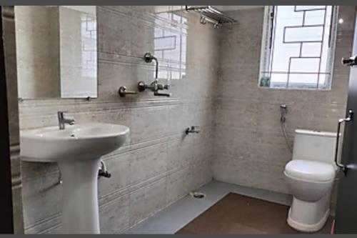 古瓦哈提HOTEL DAISY的一间带水槽和卫生间的浴室以及窗户。