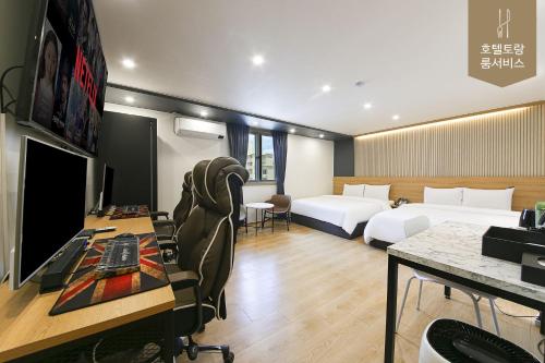 全州市Hotel Torang Jeonju的酒店客房配有两张床和一张书桌