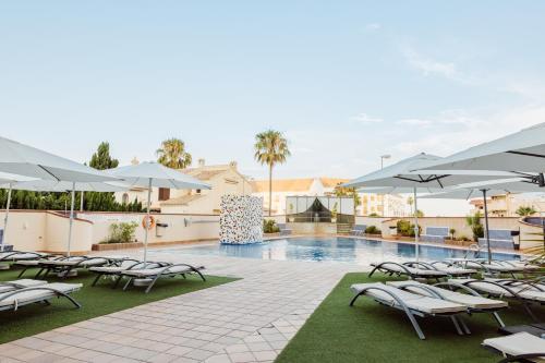拉曼加戴尔马尔梅纳拉斯加维奥塔斯酒店的一个带躺椅和遮阳伞的游泳池