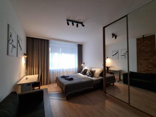 格丁尼亚Apartament 51的一间卧室配有一张床和一面大镜子