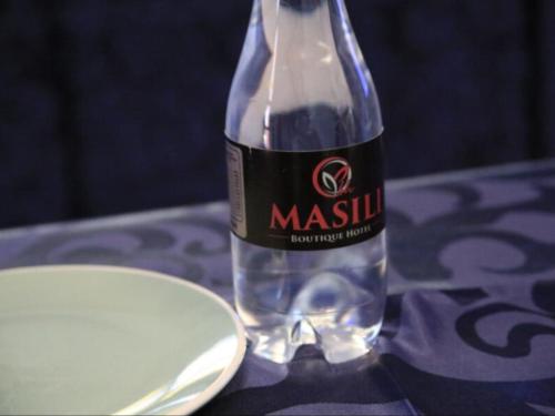 路易特里哈特Masili Boutique Hotel的桌子上坐着一瓶水