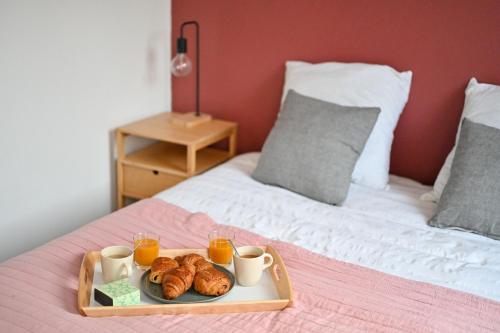 埃特勒塔LA DAME - ETRETAT的床上的羊角面包和橙汁托盘