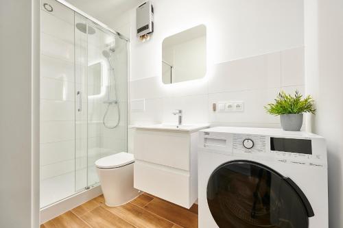 奥尔什丁Apartament Barczewski, 2 pokoje i kuchnia的白色的浴室设有洗衣机和水槽。