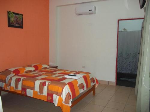 伊基托斯Casa Linda II的一间卧室设有一张床和橙色的墙壁