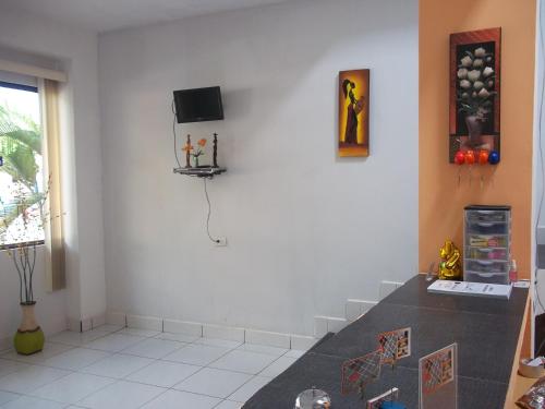 伊基托斯Casa Linda II的客厅配有桌子和墙上的电视