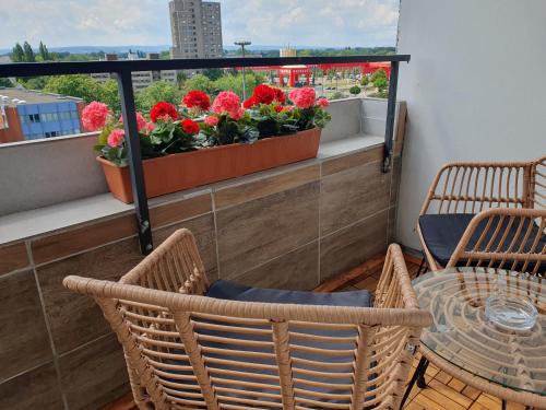 汉诺威LANE City Laatzen的阳台配有桌椅和鲜花。