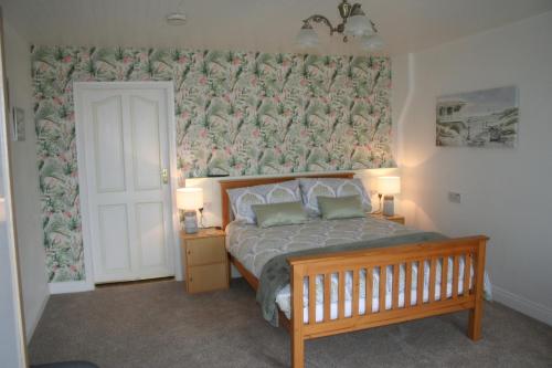 安纳斯考尔Swallows Rest的一间卧室配有一张带花卉壁纸的床