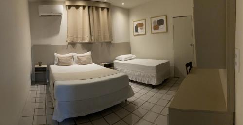 卡鲁阿鲁Center Plaza Hotel的酒店客房设有两张床和窗户。