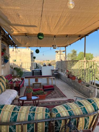 安曼Darna Hostel的屋顶上带沙发和桌子的庭院