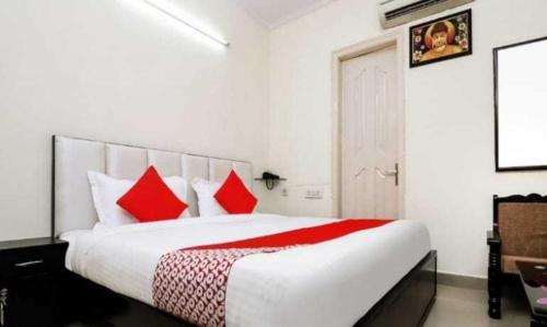 珀勒德布尔OYO Hotel Kamal的一间卧室配有一张带红色枕头的大床