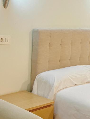 毕尔巴鄂Apartamentos Lidar的一间卧室配有两张床和床头板