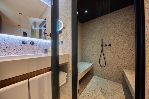 马尔切西内拜亚维尔德酒店的设有带步入式淋浴间和盥洗盆的浴室