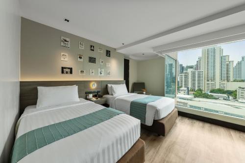 曼谷金色郁金香麦迪逊套房酒店的配有大窗户的酒店客房内的两张床