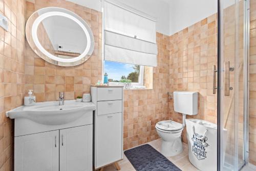 卡布鲁尼齐Villa Pietro的一间带水槽、卫生间和镜子的浴室