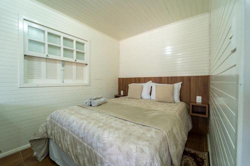 邦雅尔丁-达塞拉Chalés da Tribo的一间卧室设有一张大床和窗户