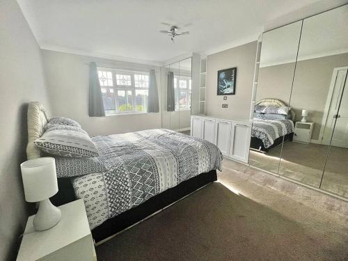 Great CoatesCosy Modern Grimsby Home的一间卧室设有两张床和大镜子