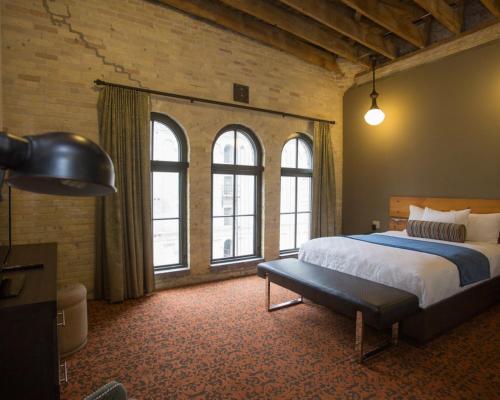 密尔沃基啤酒厂酒店的一间卧室设有一张大床和窗户。