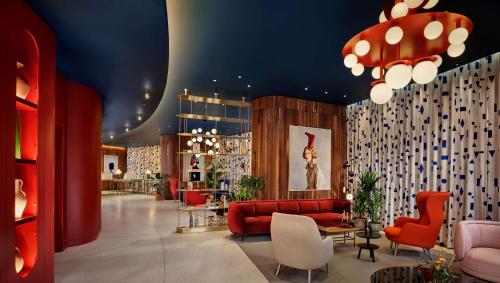 伦敦art'otel London Battersea Power Station, Powered by Radisson Hotels的大堂设有红色的沙发和椅子