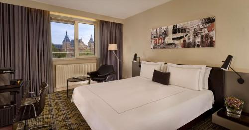 阿姆斯特丹公园广场酒店&度假村的酒店客房设有一张白色大床和一个窗户。
