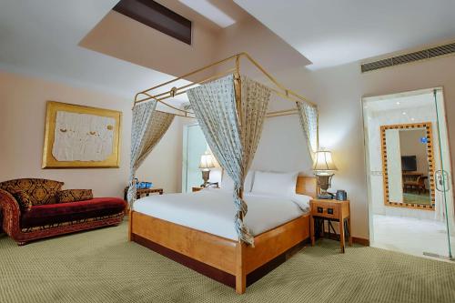 亚历山大亚历山大绿色广场希尔顿酒店的一间卧室配有天蓬床和沙发