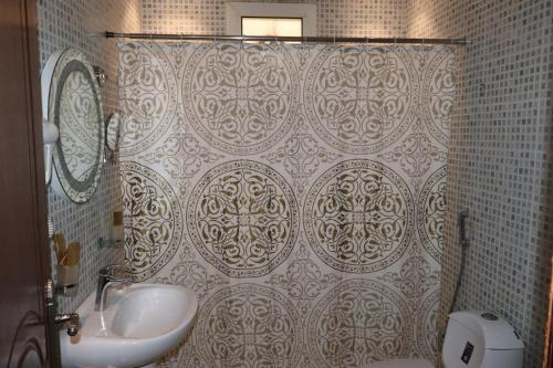 利雅德Al Bateel Furnished Apartments的浴室配有淋浴帘和盥洗盆。