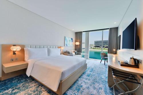 麦纳麦Hilton Garden Inn Bahrain Bay的酒店客房设有一张大床和一张书桌。