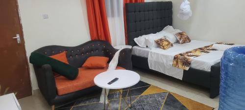 蒙巴萨Davkin Apartments的一间卧室配有一张床、一把椅子和一张桌子