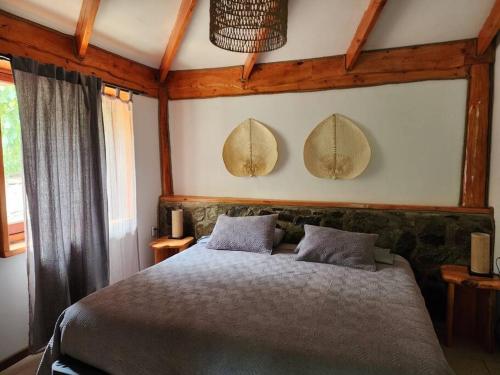 圣阿方索Cabaña de montaña (jacuzzi exterior)的卧室配有一张床,墙上有两面镜子