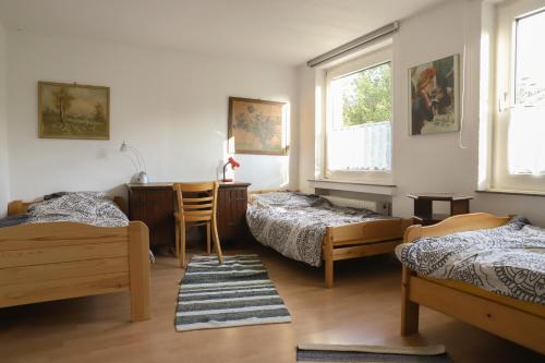 达特尔恩Gasthaus Benke, Fachwerkhaus in Westfalen的客房设有三张床、一张书桌和一张书桌