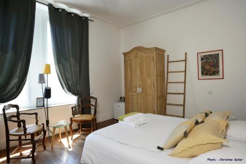 萨林德吉罗恩倪温卡马格酒店的一间卧室设有一张床、两把椅子和梯子