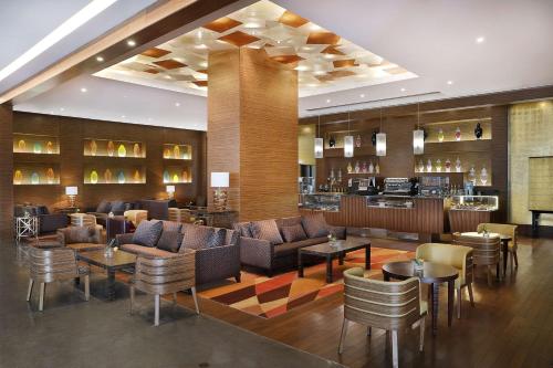 利雅德Hilton Riyadh Hotel & Residences的酒店大堂设有沙发和桌子,还有一间酒吧