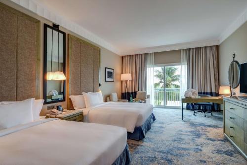 塞拉莱塞拉莱度假村希尔顿酒店的酒店客房配有两张床和一张书桌