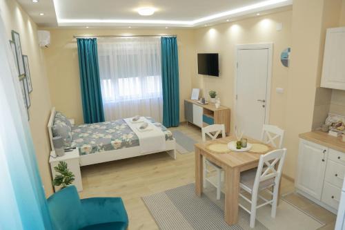 皮罗特Vila Harmony的小房间设有一张床、一张桌子和椅子