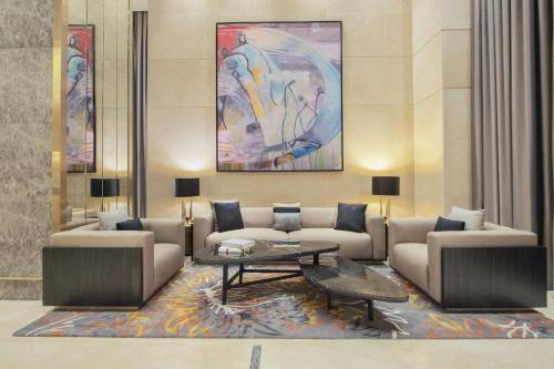 多哈Hilton Doha The Pearl的大堂配有沙发、桌子和绘画作品