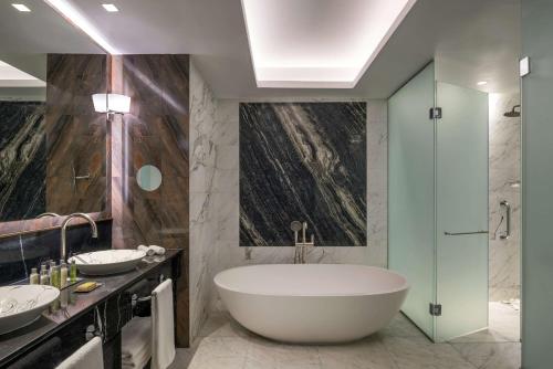 HauaraHilton Tangier Al Houara Resort & Spa的浴室配有两个盥洗盆和浴缸。