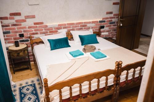 乌尔齐尼Guest house Mirah的一张带两个蓝色枕头和砖墙的床