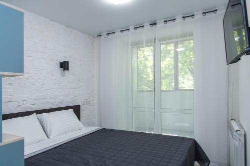 基辅MYFREEDOM Апартаменти метро Берестейська的一间卧室设有一张床和一个滑动玻璃门