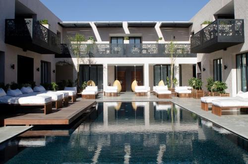 马拉喀什塞萨尔Spa度假酒店的一座带椅子的游泳池和一座建筑的酒店