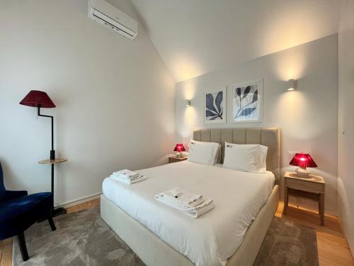 波尔图Nomads Lux - 2BDR Almada Private Porto的卧室配有白色的床和蓝色椅子