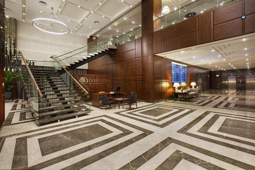 伊斯坦布尔伊斯坦布尔阿弗希拉尔希尔顿逸林酒店的大堂设有楼梯和桌椅