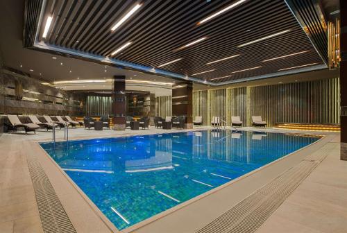 伊斯坦布尔伊斯坦布尔克孜亚塔吉希尔顿酒店的大楼内一个蓝色的大型游泳池