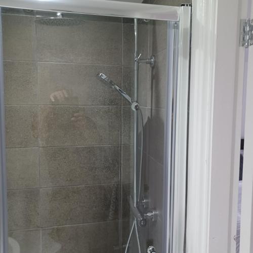 惠特比Premier house的浴室里设有玻璃门淋浴