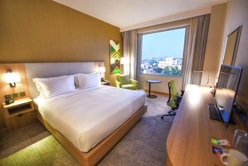 坎帕拉Hilton Garden Inn Kampala的一间设有大床和窗户的酒店客房