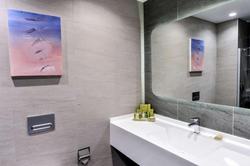 安卡拉DoubleTree by Hilton Ankara Incek的浴室设有白色水槽和镜子